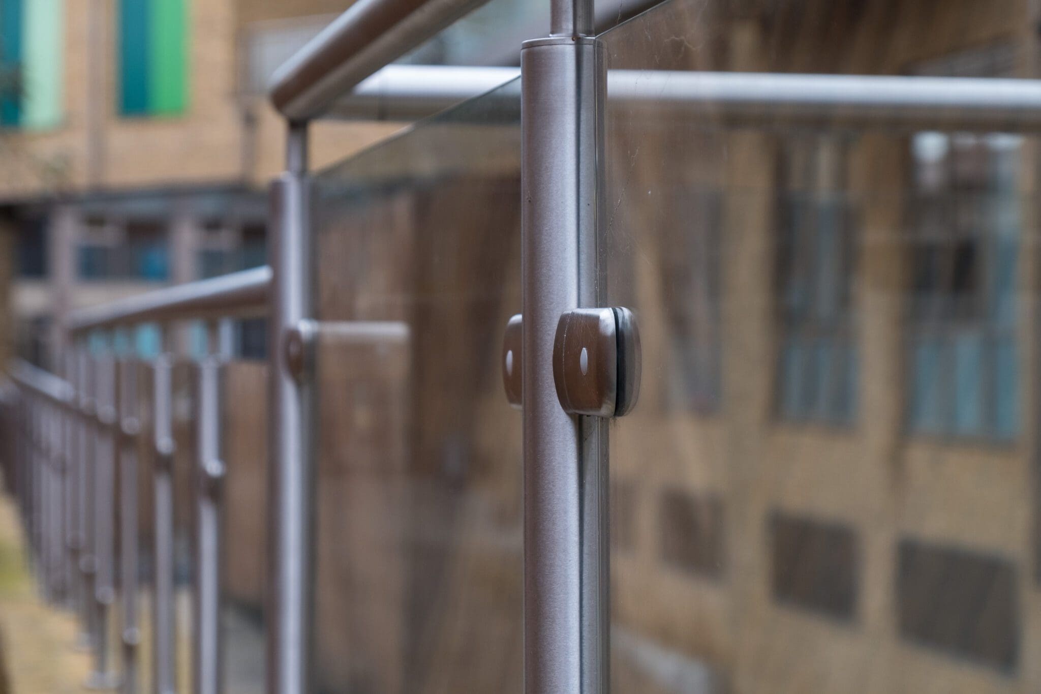 Close-up of aluminium top rail on Neaco Clearview balcony, featuring toughened glass panels