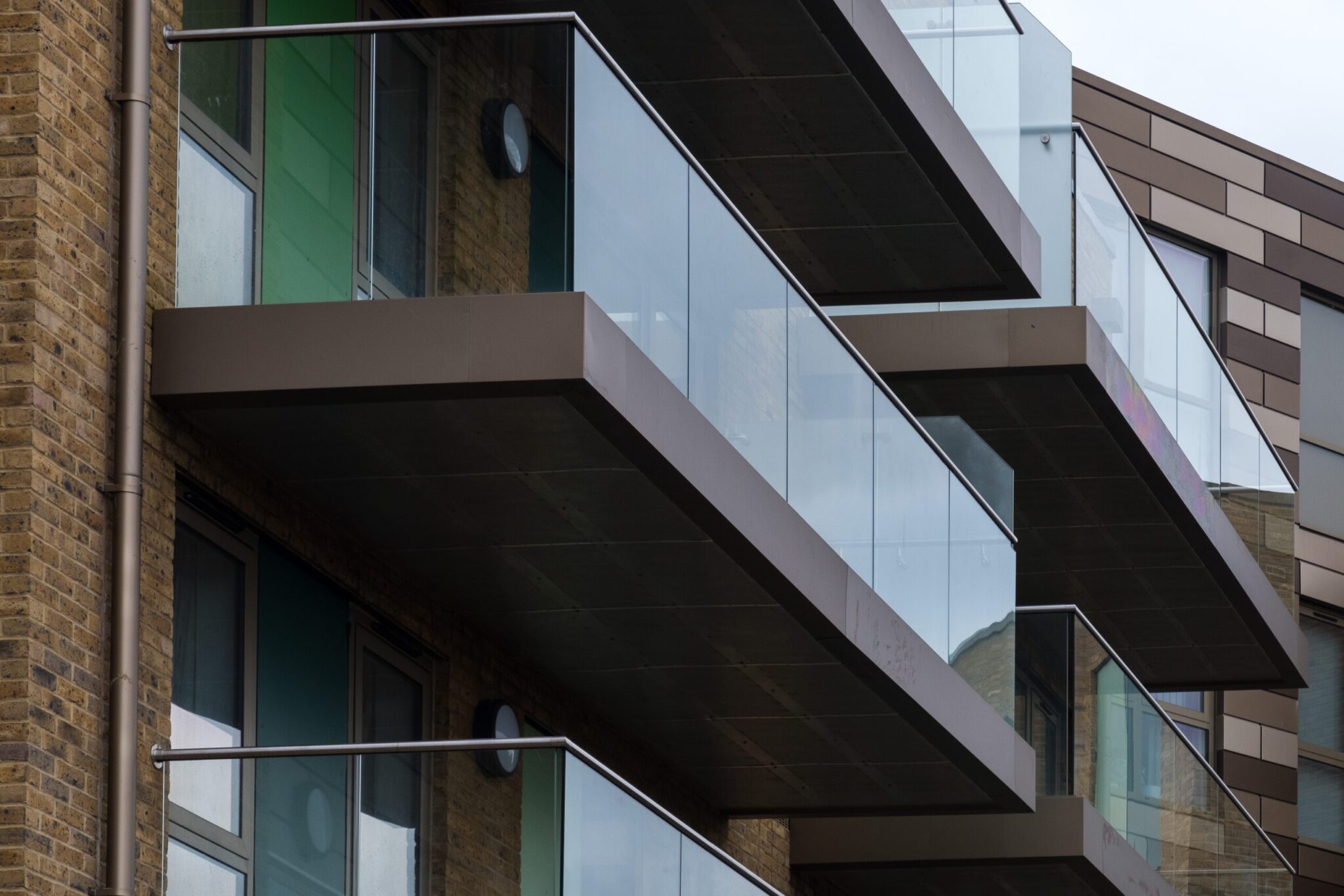 Continuous glass-fronted balcony with aluminium top rail and floor channels