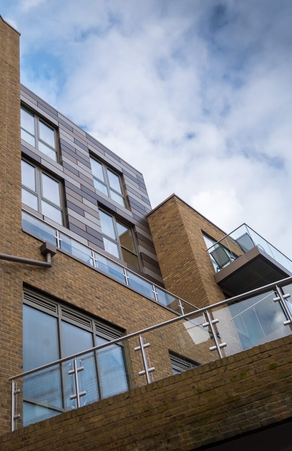 Structural glass balcony with tinted glass panels and aluminium top rail at Clapham development